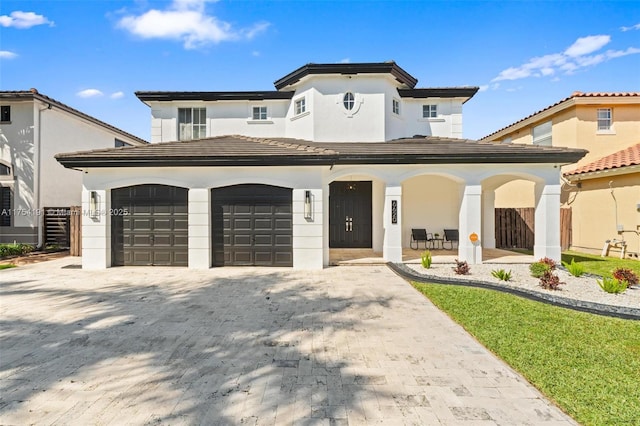 view of front of property with an attached garage, a porch, and decorative driveway