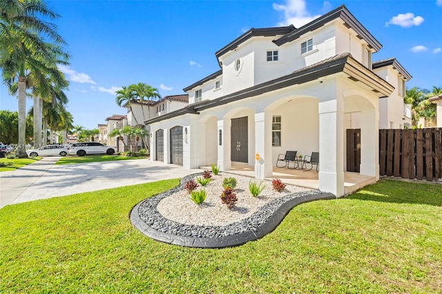 back of property with a garage, fence, concrete driveway, a lawn, and stucco siding