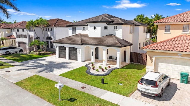 mediterranean / spanish house with a garage, a tiled roof, decorative driveway, a residential view, and stucco siding