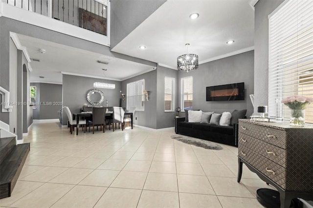 living room with ornamental molding, a notable chandelier, and light tile patterned floors