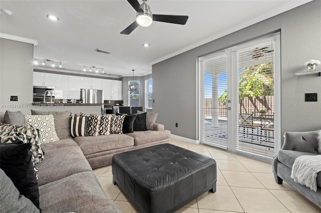 living area featuring visible vents, baseboards, ornamental molding, rail lighting, and light tile patterned flooring