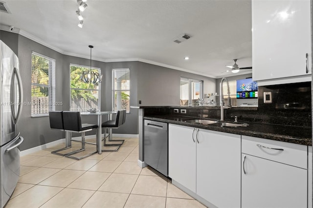 kitchen featuring crown molding, light tile patterned floors, stainless steel appliances, white cabinetry, and a sink