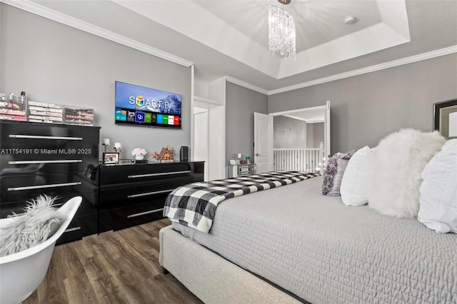 bedroom featuring crown molding, a chandelier, a raised ceiling, and dark wood-type flooring