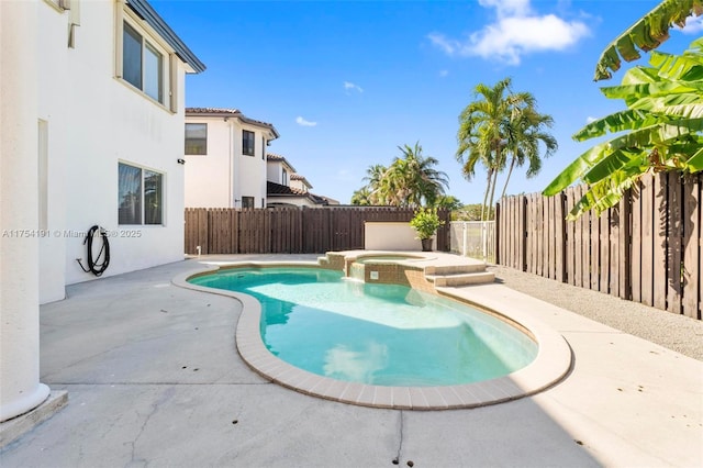 view of swimming pool featuring a patio area, a fenced backyard, and a pool with connected hot tub