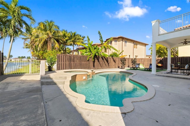 view of swimming pool with a patio, a fenced backyard, and a pool with connected hot tub