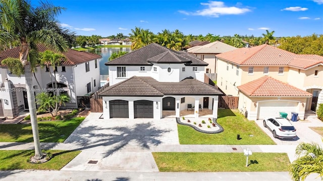 mediterranean / spanish home featuring driveway, a tiled roof, a residential view, and a front yard