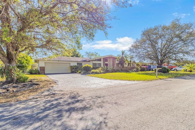 view of front of property with a garage, driveway, and a front lawn