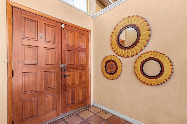 foyer entrance featuring light tile patterned flooring and baseboards