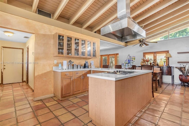 kitchen featuring a center island, island exhaust hood, visible vents, light countertops, and lofted ceiling with beams