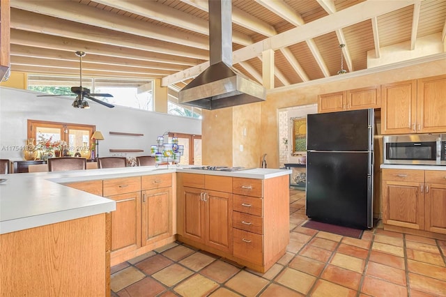 kitchen featuring lofted ceiling with beams, electric stovetop, light countertops, freestanding refrigerator, and stainless steel microwave