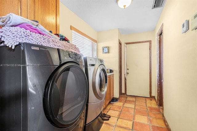 laundry room with light tile patterned floors, visible vents, cabinet space, and separate washer and dryer