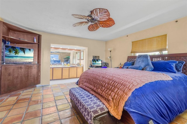 bedroom featuring ensuite bathroom, ceiling fan, and multiple windows