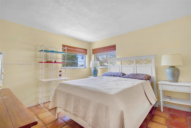 bedroom featuring a textured ceiling and baseboards