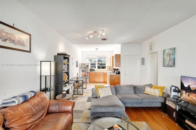 living area featuring light wood-style flooring and visible vents