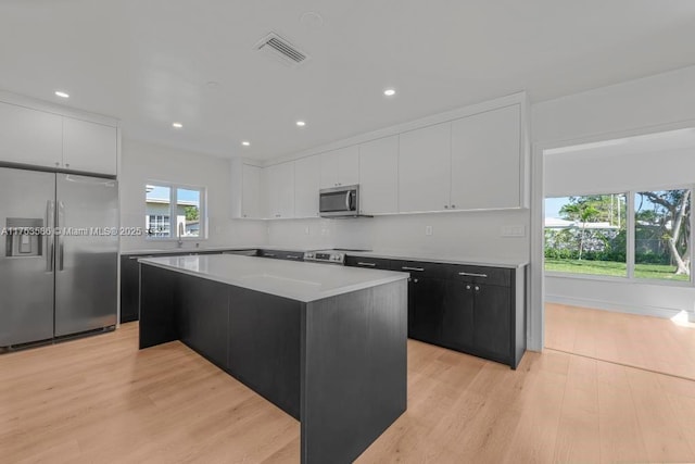 kitchen featuring light wood-style floors, white cabinetry, visible vents, and stainless steel appliances