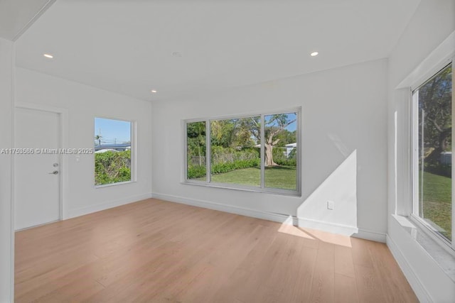 empty room featuring light wood-style floors, baseboards, and recessed lighting