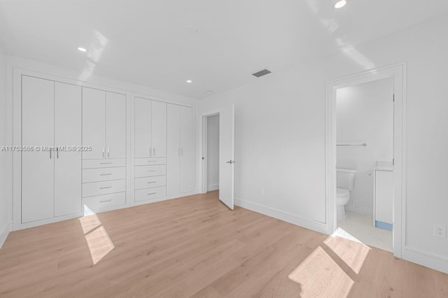 unfurnished bedroom with connected bathroom, recessed lighting, visible vents, multiple closets, and light wood-type flooring