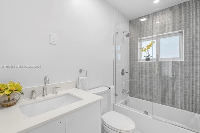 full bathroom with bath / shower combo with glass door, vanity, and toilet