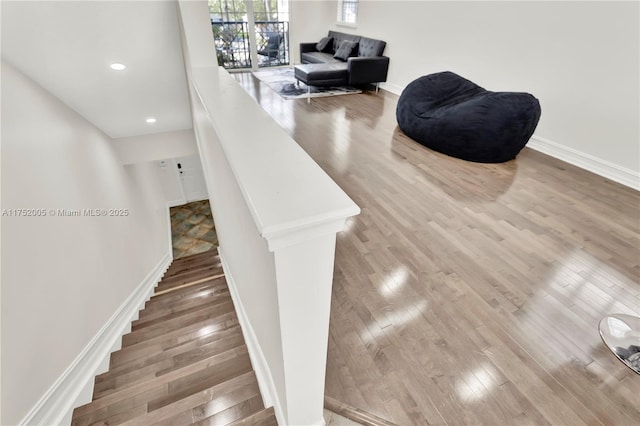 stairs featuring recessed lighting, wood finished floors, and baseboards