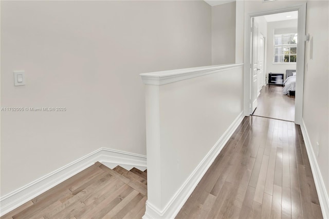 hallway with baseboards and wood finished floors