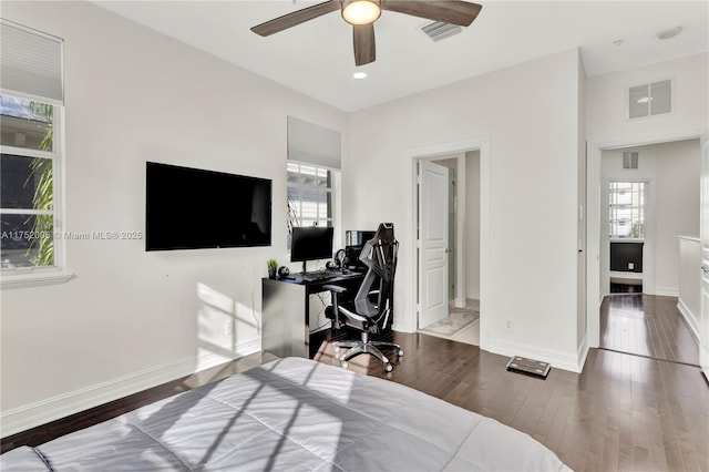 bedroom with visible vents, multiple windows, and hardwood / wood-style flooring