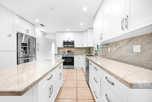 kitchen with tasteful backsplash, visible vents, appliances with stainless steel finishes, a sink, and light tile patterned flooring