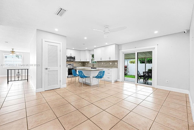 kitchen with ceiling fan, visible vents, white cabinets, appliances with stainless steel finishes, and backsplash