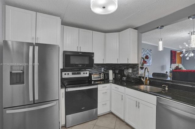 kitchen with light tile patterned floors, stainless steel appliances, tasteful backsplash, white cabinetry, and a sink