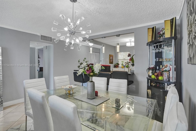 tiled dining space featuring a chandelier, visible vents, ornamental molding, and a textured ceiling