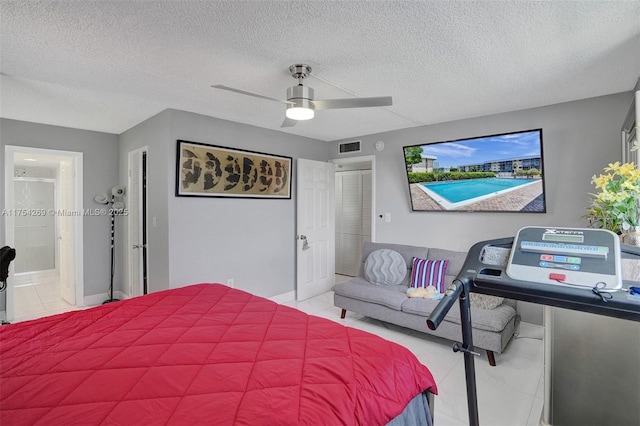 bedroom with visible vents, a textured ceiling, light tile patterned flooring, and a ceiling fan