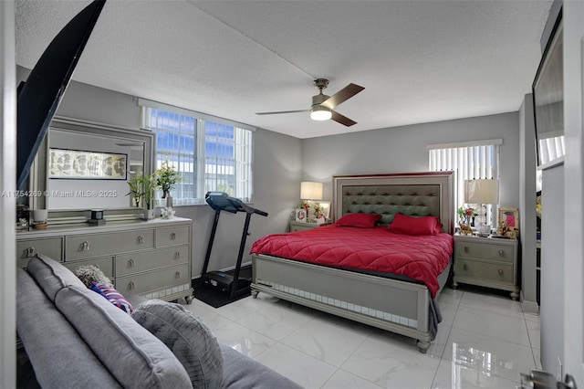 bedroom featuring ceiling fan, marble finish floor, multiple windows, and a textured ceiling