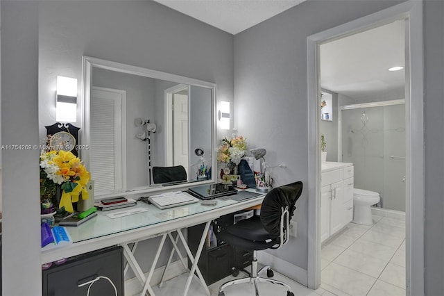 office space featuring baseboards and light tile patterned flooring