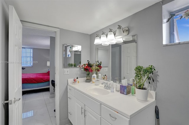 bathroom with connected bathroom, plenty of natural light, and vanity