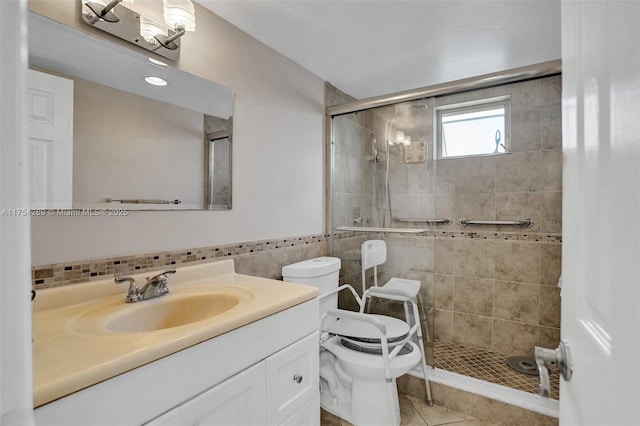 full bath with toilet, vanity, a shower stall, and tile walls