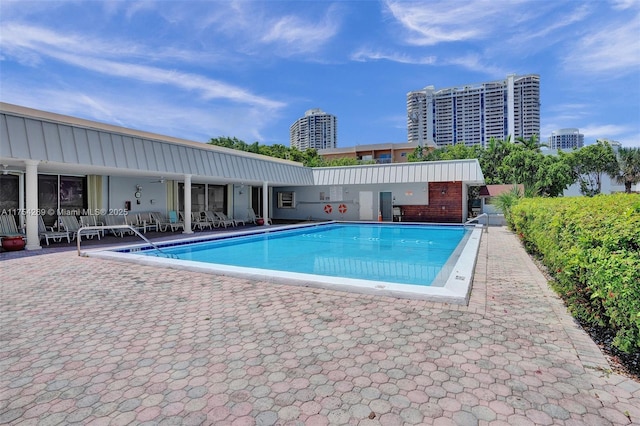 community pool with a view of city and a patio