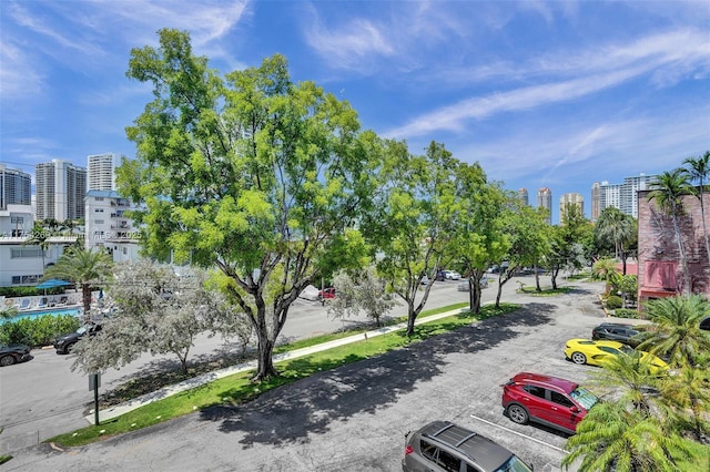 view of property's community with uncovered parking and a city view