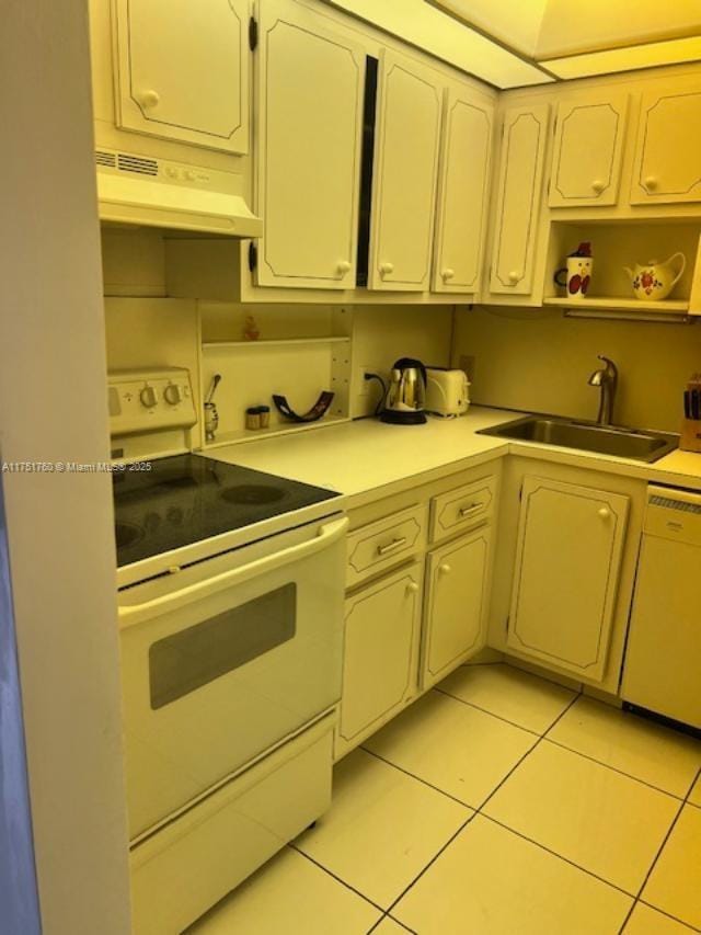 kitchen featuring light countertops, light tile patterned flooring, a sink, white appliances, and under cabinet range hood