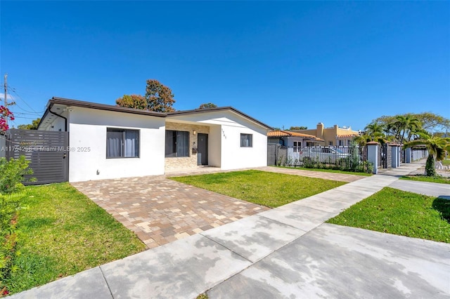 view of front of house with a fenced front yard, a front yard, and stucco siding