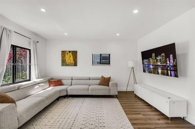 living area featuring baseboards, wood finished floors, and recessed lighting