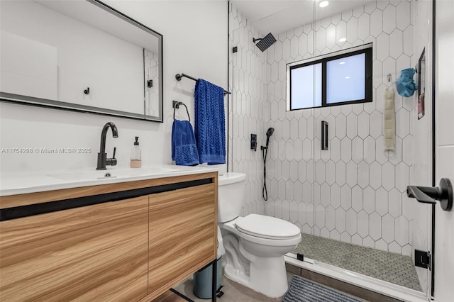 bathroom with a stall shower, vanity, and toilet