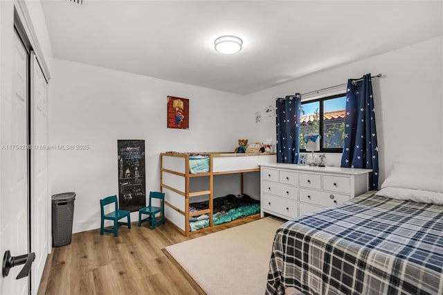 bedroom featuring light wood finished floors and a closet