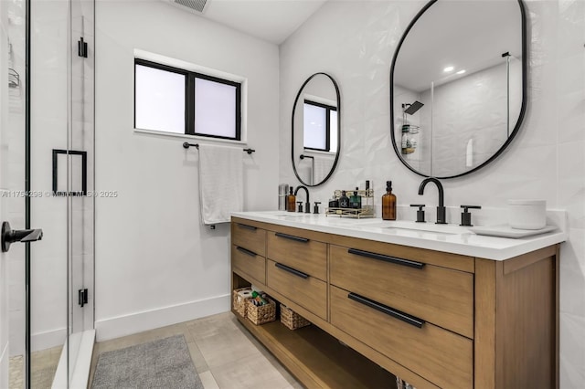 bathroom featuring a stall shower, a sink, tile walls, and double vanity