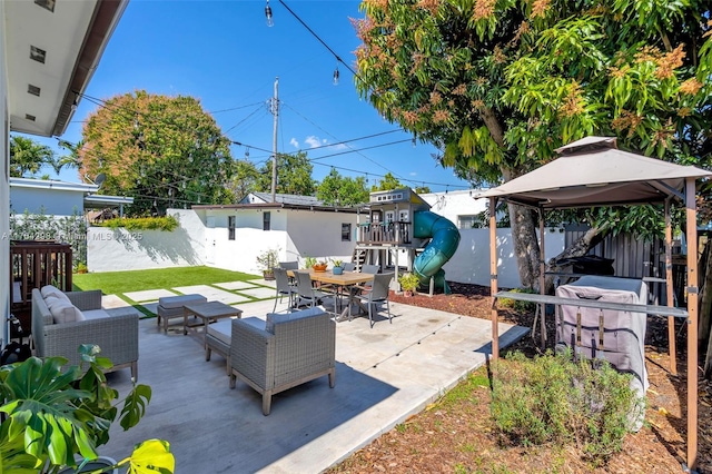 view of patio with fence, an outdoor living space, a playground, and a gazebo