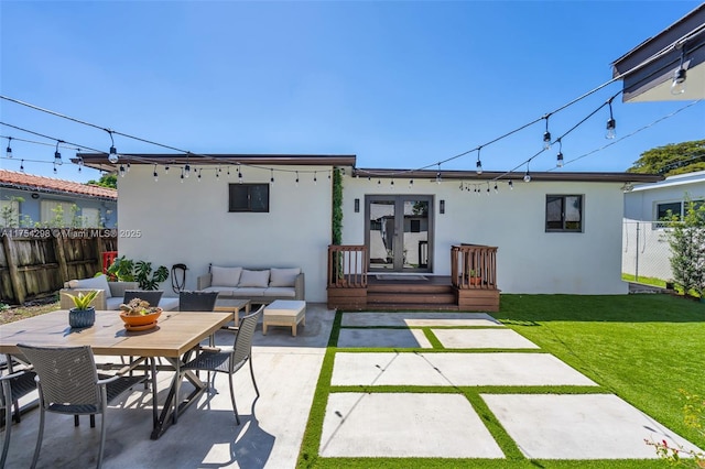 back of house featuring french doors, stucco siding, fence, and an outdoor hangout area