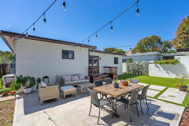 view of patio featuring outdoor dining area, fence, and an outdoor living space