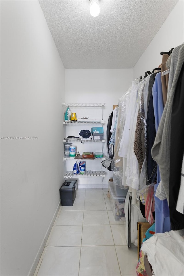 walk in closet with tile patterned flooring