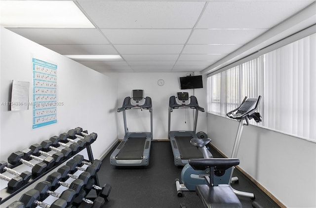 workout room with baseboards and a drop ceiling