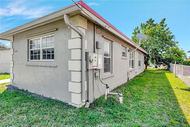 view of home's exterior featuring a yard, fence, and stucco siding