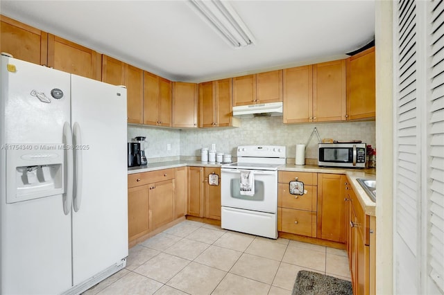 kitchen with white appliances, tasteful backsplash, under cabinet range hood, and light countertops