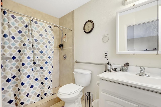 bathroom with toilet, a tile shower, and vanity